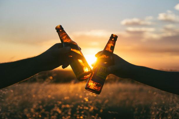 Craft Beers 2021; beer bottles being clinked against a sunset backdrop