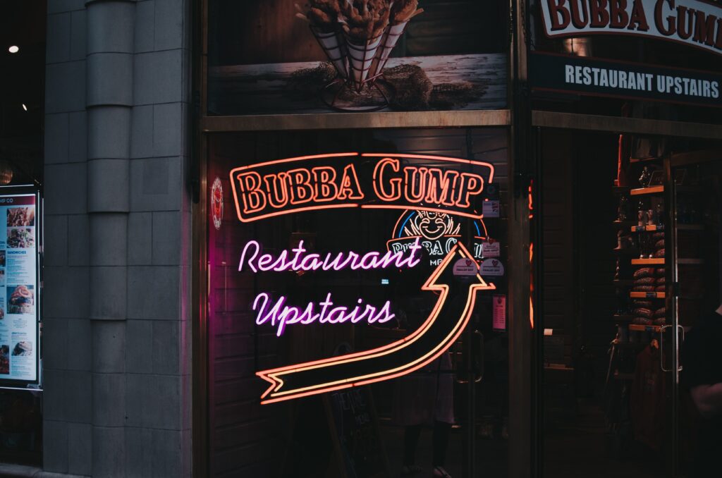 Offline Restaurant Marketing Ideas; neon signs advertising Bubba Gump restaurant with an arrow