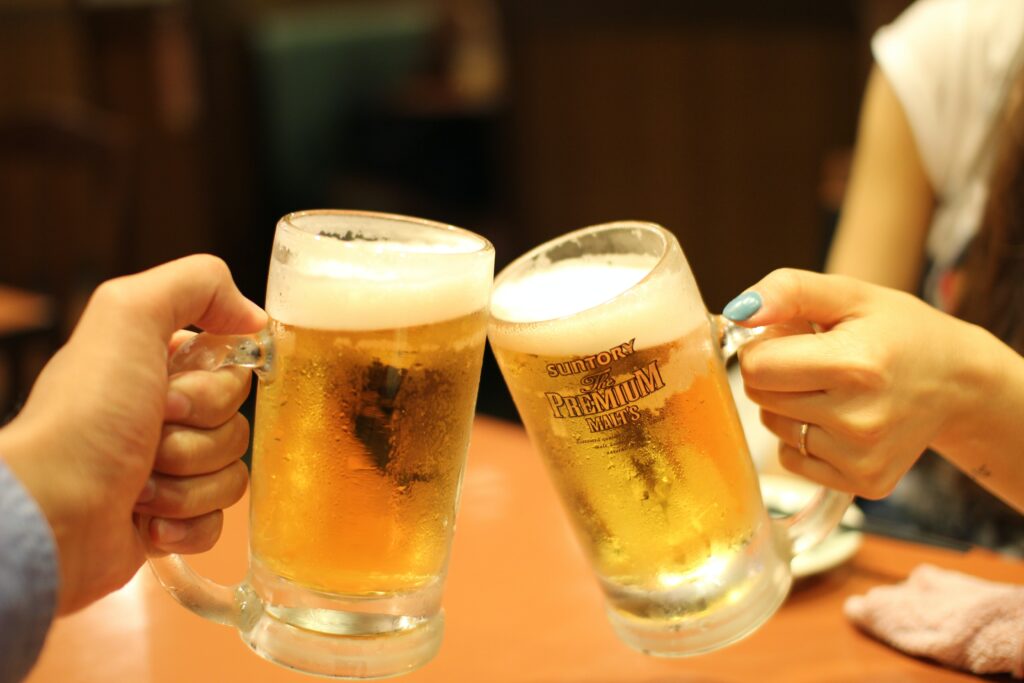 best beer brands; two hands clinking their beer glasses