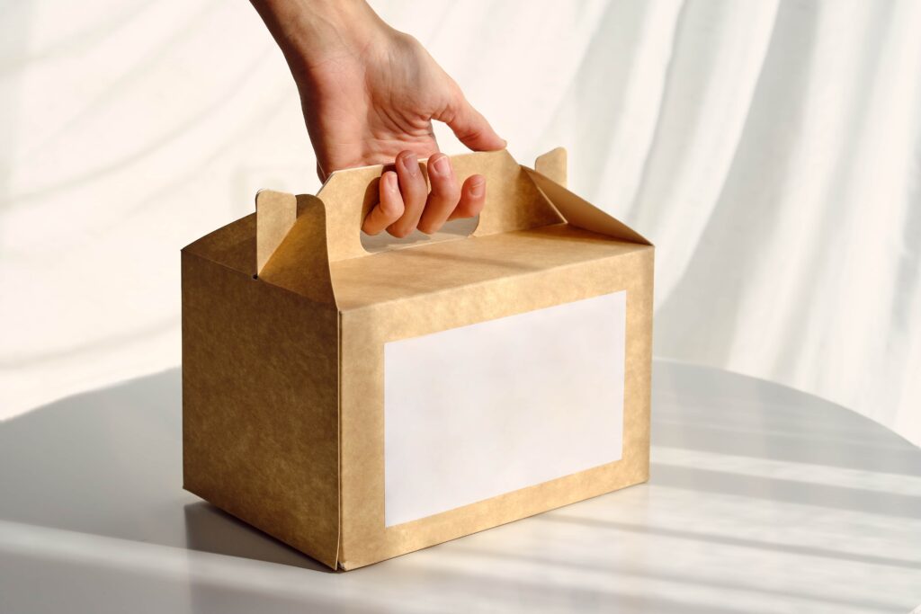 Reduce shipping costs, a hand lifting a carton box.
