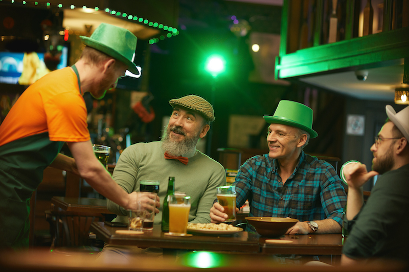 St. Patrick's Day Pub Games, people at a pub wearing green hats.