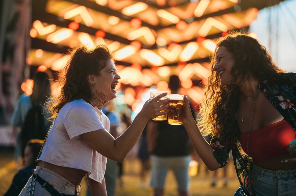 beer mat collectors, girls clinking beer glasses together at outdoor festival