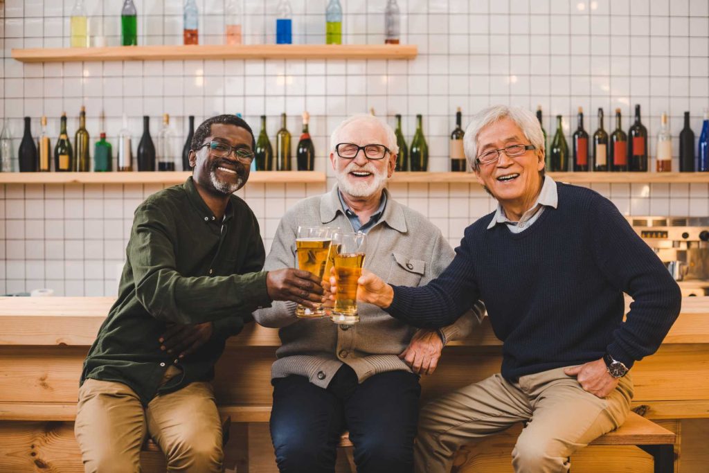 beer tasting party ideas, three men holding glasses of beer together
